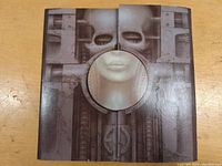 Front cover of Brain Salad Surgery LP by Emerson Lake & Palmer showing mechanical design with a human face in the center cutout.