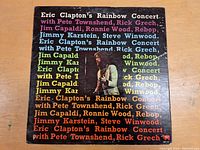 Front cover of Eric Clapton's Rainbow Concert LP showing Eric Clapton playing guitar with multi-colored text listing various featured artists repeated across the cover.