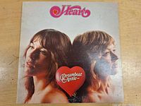 Front cover of 'Dreamboat Annie' LP by Heart, showing two individuals in profile with a red heart featuring the album name.
