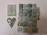 Assorted mosaic tiles featuring heart and spade embossed designs arranged on a flat surface, showing overall lot contents.