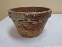 Side view of vintage clay flower pot showing distressed shabby chic finish and rounded rolled rim.
