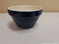 Front angle photo of dark blue ceramic mixing bowl showing interior and exterior shape, glossy finish.