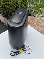 Front and top view of black Polk Command Subwoofer with power cord.