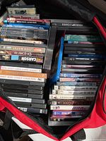 Top view showing the DVDs and VHS tapes inside a red bag with visible movie titles.