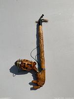 Full view of hand carved wooden pipe showing detailed animal carvings, metal mesh bowl, and attached string.