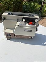 Side angle of the beige and brown Majestic Dual Eight Projector showing adjustment knobs and input ports.