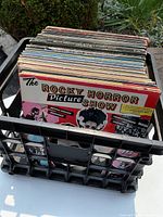 Black crate filled with assorted vinyl records, front record shown is The Rocky Horror Picture Show soundtrack.