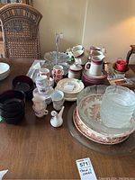 Overview of china cups and saucers with glassware and plates on wooden table