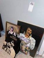Photo showing the collection of Elvis Presley items including framed images, vinyl album and guidebook.