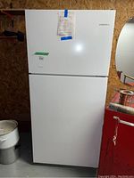 Front view of white Amana refrigerator with top freezer