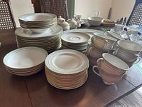 Full set of stacked plates, cups and bowls displayed on table