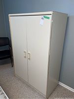 Wardrobe front view showing clean two-door design with handles, neutral color.