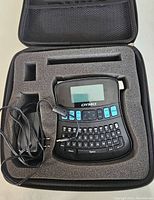 Dymo label maker, adapter and case in foam compartment inside carrying case