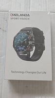 Front of sealed white retail box showing Melanda sport watch image and slogan 'Technology Changes Our Life'