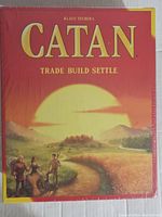 Front of Klaus Teuber's Catan board game box showing title, artwork, and sealed plastic wrapping.