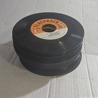 Stack of vintage 45 RPM vinyl records, showing the Flashback label on top with orange and white colors