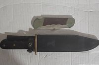Pair of knives with sheaths laid on a white surface showing size and handles