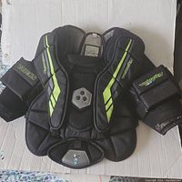 Full view of the Vaughn Velocity goalie chest protector showing front padded panels with neon green accents.