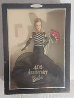 Front view of vintage 40th Anniversary Barbie doll inside the original box showing the doll in a black and silver gown holding pink flowers; the box has 'Collector Edition' label and '40th Anniversary Barbie' text on the gown.