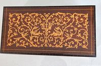 Closed rectangular wooden music box with intricate floral and bird marquetry inlay on lid