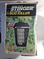 Original packaging box showing the Stinger bug killer with UV light tube and branding, claims effectiveness up to 1/2 acre.