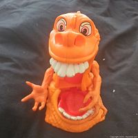 Front view of the bright orange plastic Squished Gooper figure from Kenner Ghostbusters with large teeth and open mouth showing detail inside.