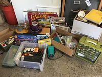 Wide shot showing full lot: boxes of art supplies, parts cabinet, electric pencil sharpener, and punch
