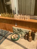 Wide shot showing chess sets, painting, vases, stones, and figurine