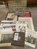 Overview of the lot showing framed prints, rosary beads, stamps, and books.