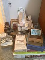 Photo showing all miniatures and finishing kits arranged on the floor including porcelain bathroom fixtures, wooden furniture, and boxed accessories