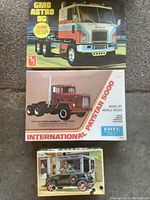 Three boxes: GMC Astro 95, International Paystar 5000 road tractor, small red sedan kit