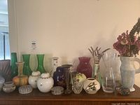 Wide view showing the full assortment of vases and canisters in different materials including glass, ceramic, and pottery.