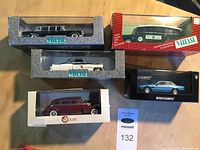 Top-down view of six boxed die-cast car models showing brands Vitesse, Minichamps, and Resval Models.