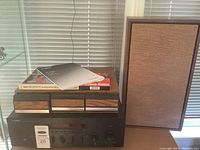 Yamaha R-S300 receiver with wooden speaker and three cassette tapes on top, showing overall lot contents.