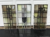 Three panels leaning against garage door on wet pavement