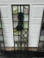 Full view of the stained glass panel showing the decorative hand motif and overall design.