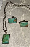 Image showing the full jewelry set consisting of a rectangular turquoise pendant on a silver chain and two matching rectangular turquoise clip-on earrings.