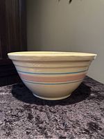 Side view of the vintage McCoy mixing bowl showing the full profile and blue and pink bands horizontally around the bowl.