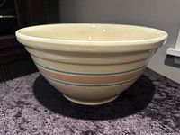 Side view of vintage McCoy pottery mixing bowl showing blue and pink horizontal bands and overall shape.