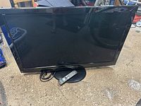 Front view of the Panasonic 42" plasma TV with remote placed on stand base, showing the screen and bezel.