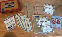 Full view showing the Bayuk Phillies cigar box and various empty war savings stamp booklets including blue, red, green and brown covers.