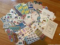 Wide-angle view of all items showing a large assortment of stamps, sheets, postcards, envelopes, and the booklet.