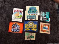 Overview of all tiles and event cards, showing colorful, detailed Volkswagen Bug Bust collector's tiles and vintage car event cards arranged on a dark fabric background.