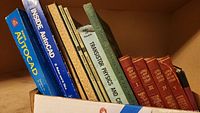 Books in a box showing bindings and titles of Audels New Electric Library volumes and Autocad manuals