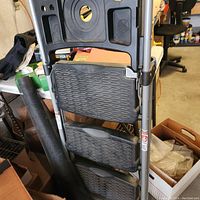 Black plastic step stool with three textured anti-slip steps