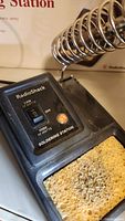 Close-up photo of soldering station control panel, showing switch, power indicator, coil spring holder, and sponge.