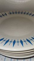 Close-up of the blue diamond pattern on white ceramic dinner plates stacked.