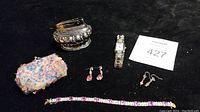 Full view of all lot items including lighter, jewelry, coin purse, and watch.