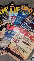 Overlapping covers of several Official UFO and People UFO Special magazines, showing major UFO-related headlines from the 1970s.