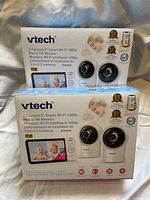Two boxed sets of Vtech 2 Camera 5" Smart Wi-Fi 1080p baby monitors with pan & tilt features.